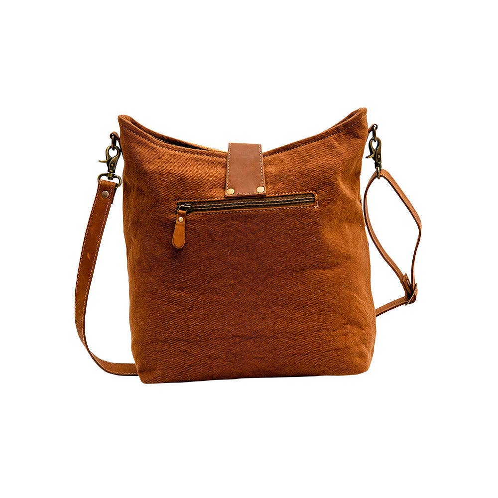 Image of Brown leather handbag with a strap on a white background