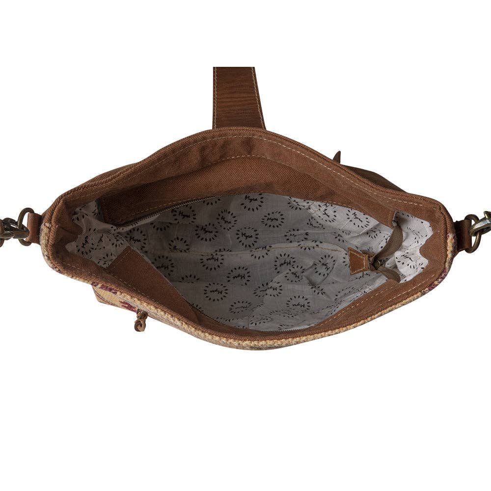 Image of Brown leather handbag with lace lining on a white background