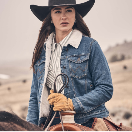 Image of Person wearing a denim jacket and cowboy hat with a blurred background