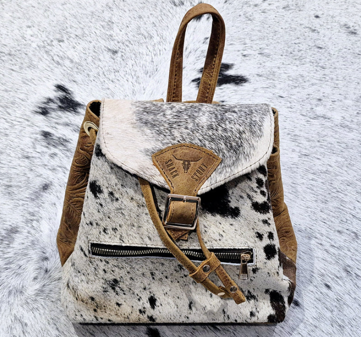 Image of Backpack with cow print pattern on a textured surface