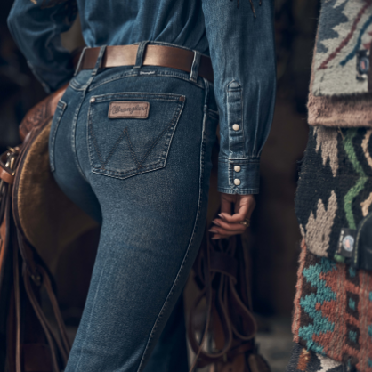 Image of Close-up of a person wearing dark blue jeans with a patterned rug in the background