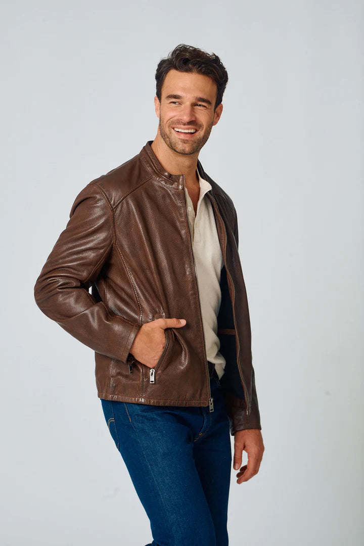 Image of Man wearing a brown leather jacket and blue jeans on a light gray background