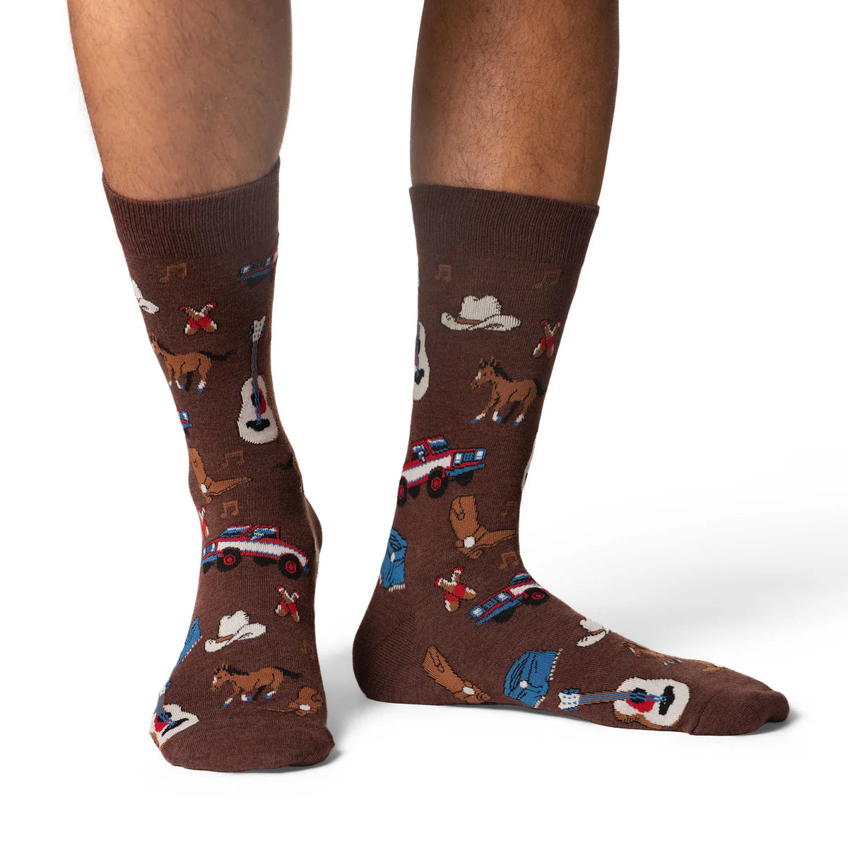 Image of Men’s brown crew socks with a playful country music pattern, shown worn for a fun western inspired look.