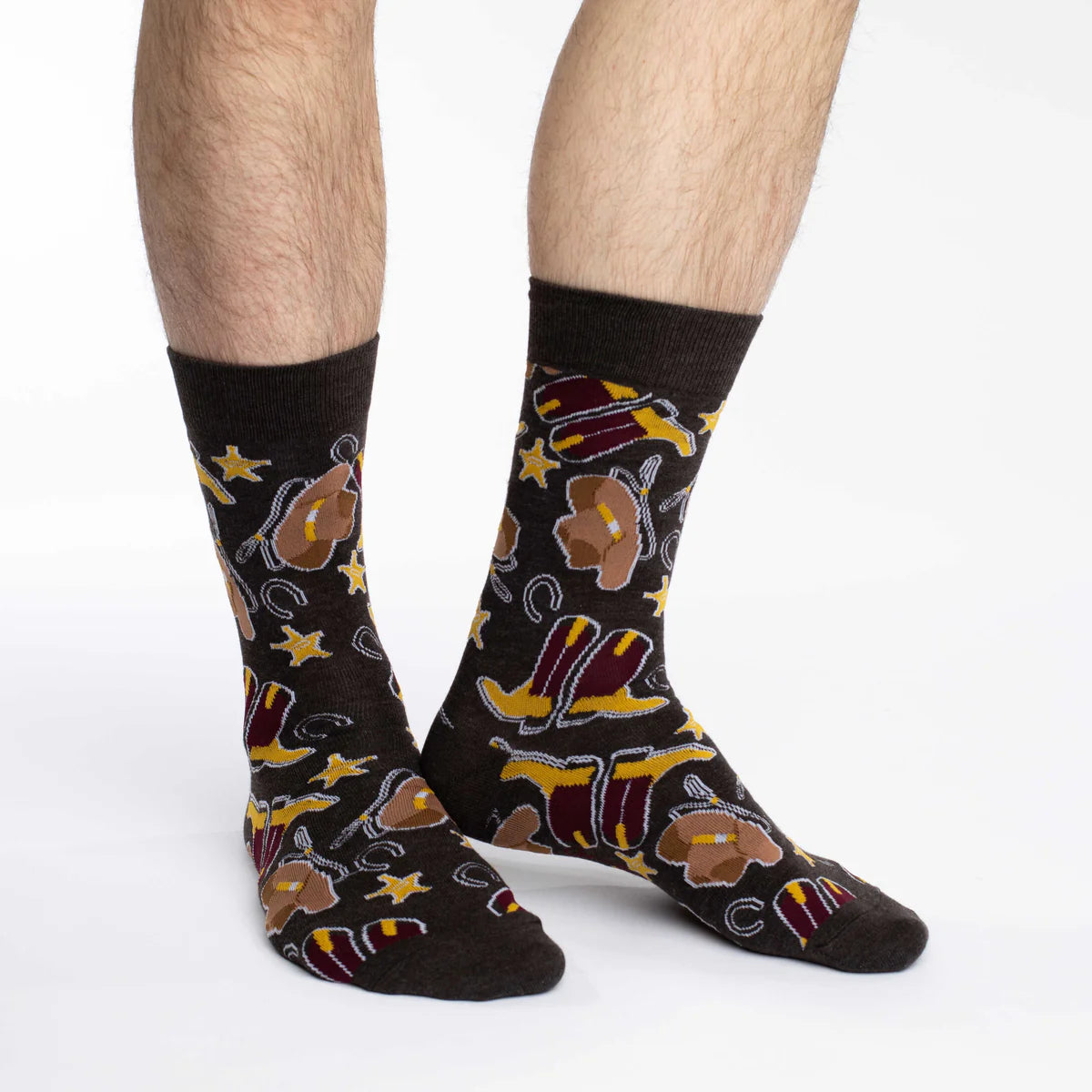 Image of Men’s dark crew socks with a playful cowboy print, shown worn for a bold western inspired look.