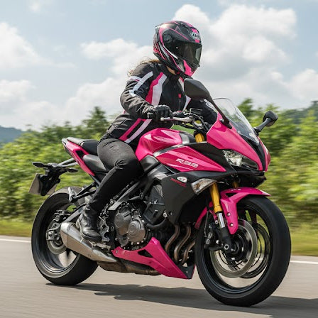 Image of Person riding a pink motorcycle on a scenic road with mountains in the background