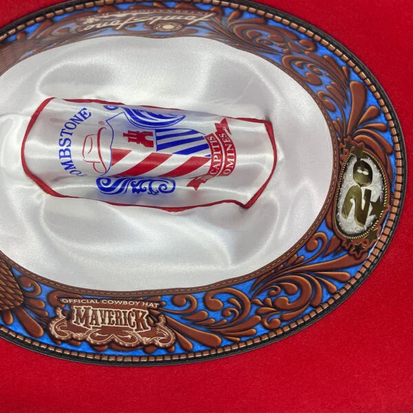Image of Decorative cowboy hat with intricate designs and a logo on a red background