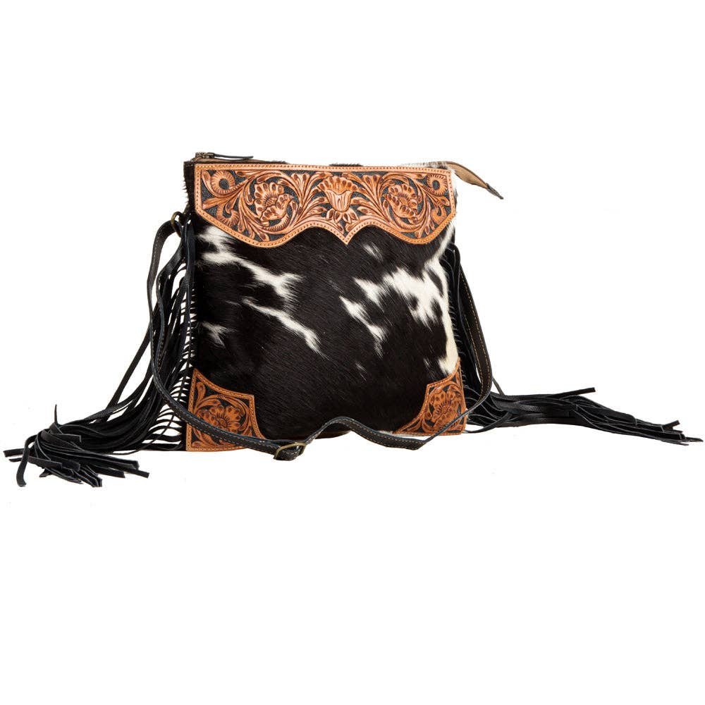 Image of Cowhide leather handbag with intricate tooled leather design and fringes on a white background