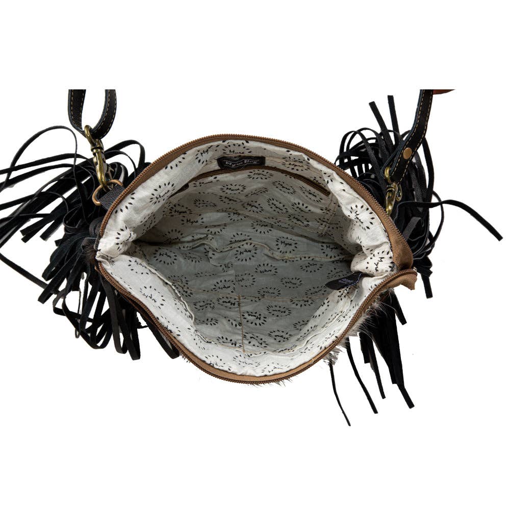 Image of Handbag with black fringes and a patterned interior on a white background