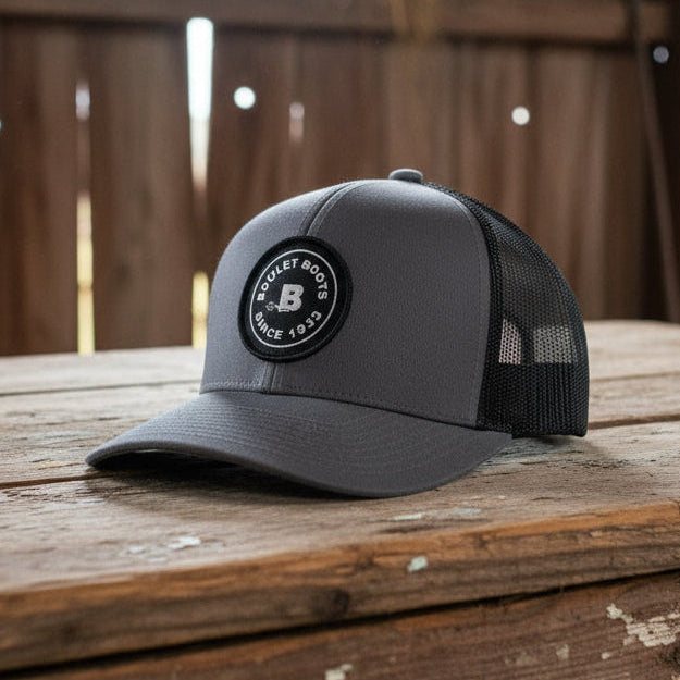 Image of Gray cap with black mesh back and logo on a white background