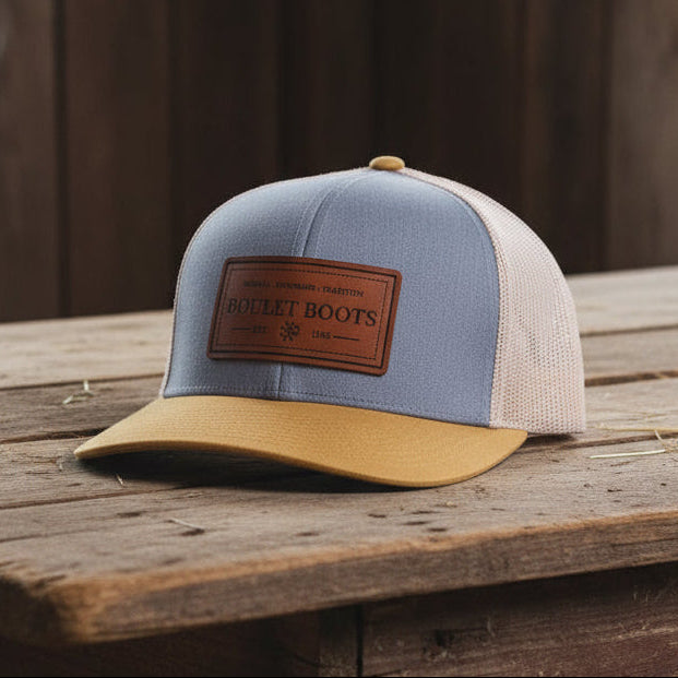 Image of Gray and beige cap with a brown leather patch on a white background