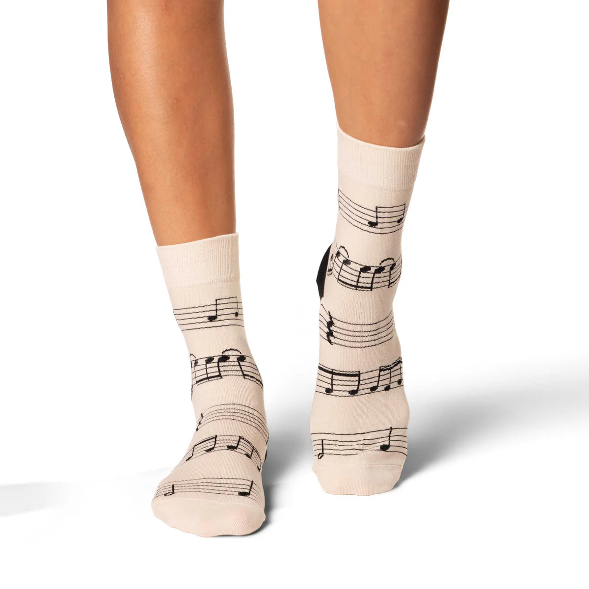 Image of Women’s ivory socks with a sheet music pattern, shown worn for an elegant music inspired look.