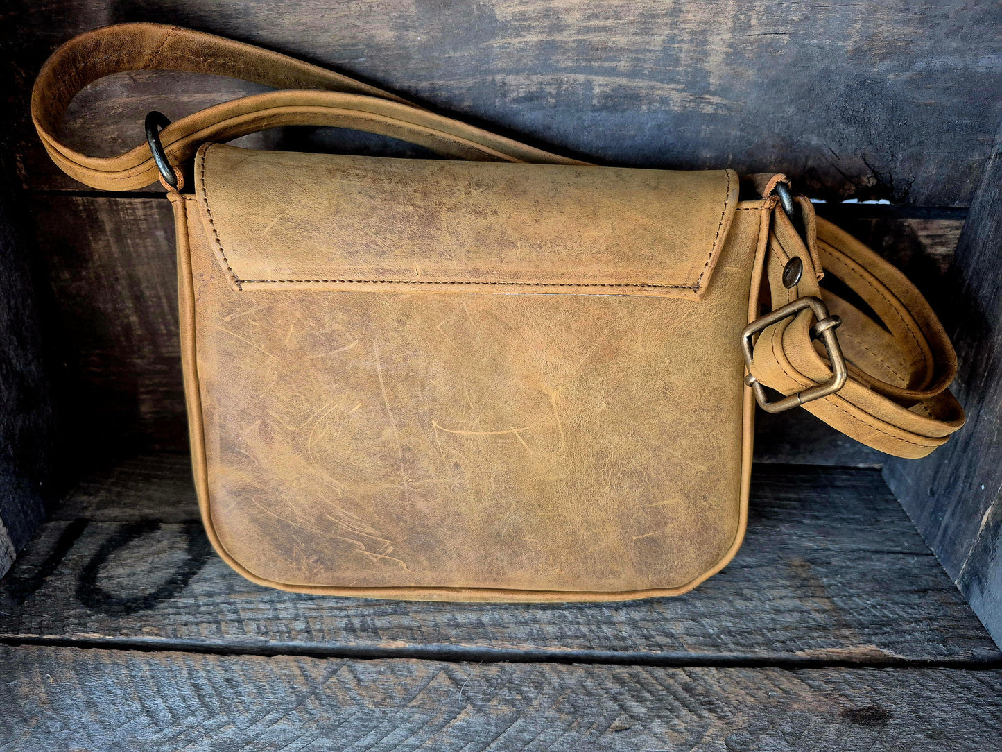 Image of Brown leather bag on a wooden surface