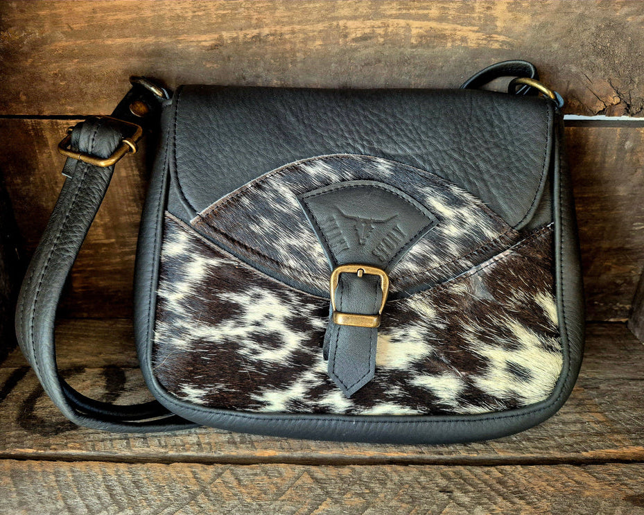Image of Handbag with cowhide pattern on a wooden surface